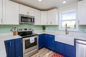 uma cozinha azul com armários brancos e um lavatório em Eagle's Rest by Pristine Properties Vacation Rentals em Indian Pass