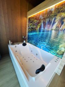 bañera en una habitación con una pintura en la pared en Cabañas Fisterra, en Finisterre 37 fotos más