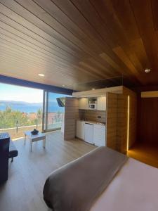 Un dormitorio con una cama grande y una ventana grande. en Cabañas Fisterra, en Finisterre