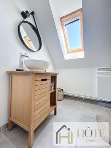ein Bad mit einem Waschbecken und einem Spiegel in der Unterkunft Appartement F2, hyper centre in Bray-Dunes