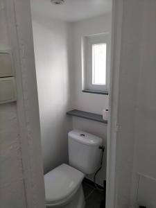 a white bathroom with a toilet and a window at Studio climatisé intra muros balcon in Avignon