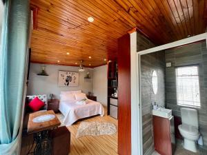 a bedroom with a bed and a wooden ceiling at SharronDeez in Cape Town