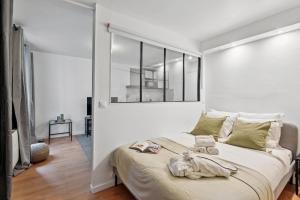 ein Schlafzimmer mit einem großen Bett mit einer weißen Wand in der Unterkunft Le Marais - CityApartmentStay in Paris