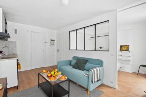 ein Wohnzimmer mit einem blauen Sofa und einem Tisch in der Unterkunft Le Marais - CityApartmentStay in Paris