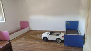 a small white car in a room with beds at Standing famillial tipaza bouismail in Bou Ismaïl