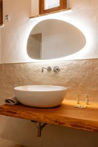 ein weißes Waschbecken auf einer Holztheke mit einem Spiegel in der Unterkunft ASSO DI PICCHE in Siena
