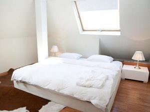 a bedroom with a bed with white sheets and a window at VISIONAPARTMENTS Waffenplatzstrasse - contactless check-in in Zürich