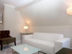 a living room with a white couch and a table at VISIONAPARTMENTS Waffenplatzstrasse - contactless check-in in Zürich