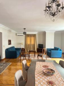 Maadi Serenity:3BR Inviting Home في القاهرة: غرفة معيشة بأثاث ازرق وثريا