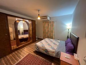 een hotelkamer met een bed en een spiegel bij Maadi Serenity:3BR Inviting Home in Caïro