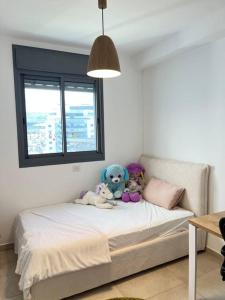 a bedroom with a bed with stuffed animals on it at בין הים לכרמל in Tirat Karmel