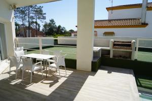 un patio con tavolo e sedie sul balcone. di Chalet blanco con piscina privada a Isla Cristina
