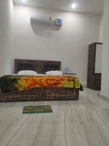 een bed in een witte kamer met bij Manglam house in Ayodhya