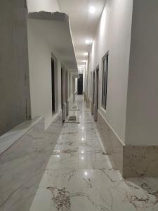 un pasillo vacío con paredes blancas y suelo de mármol en Manglam house, en Ayodhya