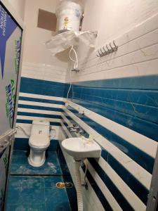 een badkamer met een toilet en een wastafel bij Manglam house in Ayodhya