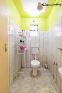 a bathroom with a toilet and a sink at Spacious 2-BR Apartment In Membley in Ruiru
