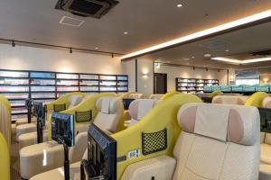 an empty room with yellow and white chairs at Tokyo Toyosu Manyo Club in Tokyo