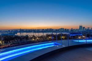 a swimming pool on the roof of a building at night at Tokyo Toyosu Manyo Club in Tokyo