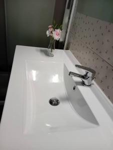 a white bathroom sink with a vase of flowers on it at CASA TURRI in Como