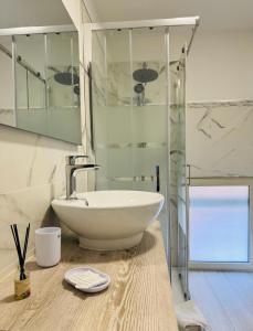 a bathroom with a sink and a glass shower at Casa vacanze in centro! in Caltagirone