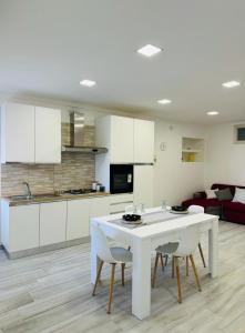 eine Küche und ein Wohnzimmer mit einem weißen Tisch und Stühlen in der Unterkunft Casa vacanze in centro! in Caltagirone