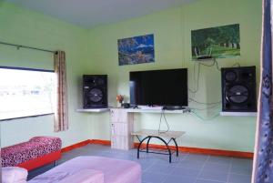 un soggiorno con TV a schermo piatto e altoparlanti di ตาลฟ้ารีสอร์ท (Tanfah Resort) a Ban Nong Khang