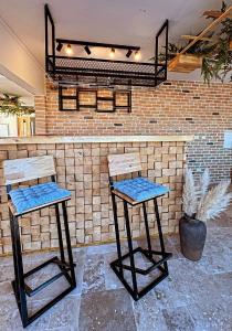 two bar stools in front of a brick wall at B'LEK SEA RESORT in 2 Mai