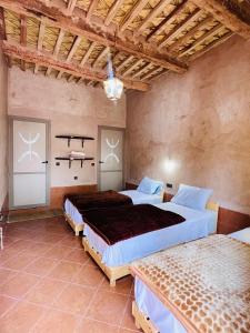 扎戈拉的住宿－Camping auberge palmeraie d'amezrou，一间卧室,配有两张床