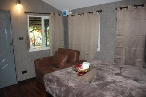a bedroom with a couch and a table with a candle at Do Dee Cafe Bangkok Hostel in Bangkok