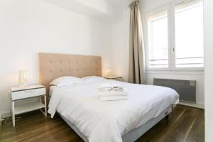 een slaapkamer met een groot wit bed en een raam bij Arts et Métiers & Upper Marais - CityApartmentStay in Parijs