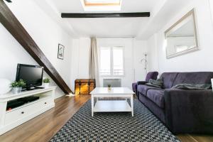 een woonkamer met een paarse bank en een tv bij Arts et Métiers & Upper Marais - CityApartmentStay in Parijs