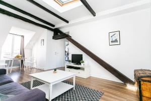 een woonkamer met een bank en een tafel bij Arts et Métiers & Upper Marais - CityApartmentStay in Parijs