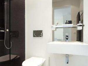 een badkamer met een wastafel, een toilet en een spiegel bij VISIONAPARTMENTS Zweierstrasse - contactless check-in in Zürich