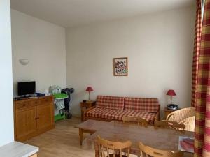 uma sala de estar com um sofá e uma mesa em Résidence Les Iles Britanniques em La Bourboule