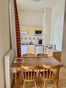 a kitchen with a wooden table and chairs in a room at Résidence Les Iles Britanniques in La Bourboule