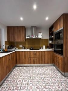 una cucina con armadi in legno e pavimento piastrellato di Hab en piso céntrico a 10min del lago a Banyoles