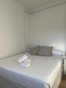 un letto bianco con due asciugamani sopra di Hab en piso céntrico a 10min del lago a Banyoles