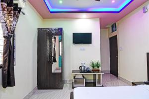 een kamer met een bed en een televisie aan het plafond bij OYO HOTEL FLOWRA in Jangipur