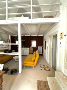 een woonkamer met een gele bank onder een hoogslaper bij La Dimora dei Mille in Ostuni