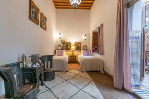 a living room with two beds and a window at Riad Les Trois Palmiers El Bacha in Marrakech +152 photos
