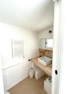een witte badkamer met een wastafel en een bad bij La Dimora dei Mille in Ostuni