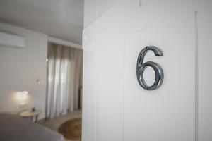 een deur met nummer zes erop in een slaapkamer bij Votsalo Tolo in Tolo