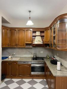 a kitchen with wooden cabinets and a stove top oven at LuxurySeaview Apartment in Durrës