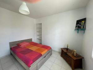 a bedroom with a bed with a colorful blanket at La maison de la plage in Saint-Georges-dʼOléron