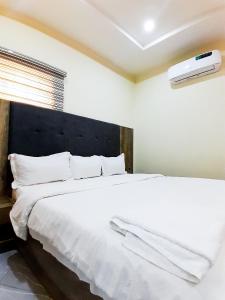 a bedroom with a large bed with white sheets at Come Inn Hotel in Rubuchi