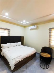 a bedroom with a large bed and a chair at Come Inn Hotel in Rubuchi