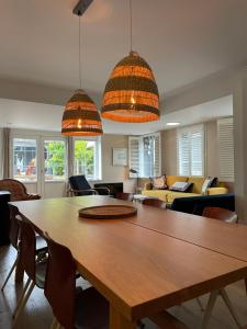 a living room with a wooden table and chairs at Fisherman's Cottage - Surf Retreat in Wijk aan Zee