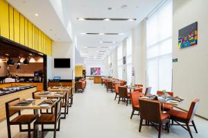 a dining room with tables and chairs in a restaurant at Fairfield by Marriott Ahmedabad in Ahmedabad
