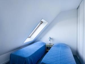 een blauwe kamer met 2 bedden en een raam bij Appartement Carnac, 3 pièces, 6 personnes - FR-1-477-63 in Carnac