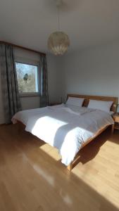 a bedroom with a large white bed with a window at Ferienwohnung Familie Haas in Gößweinstein